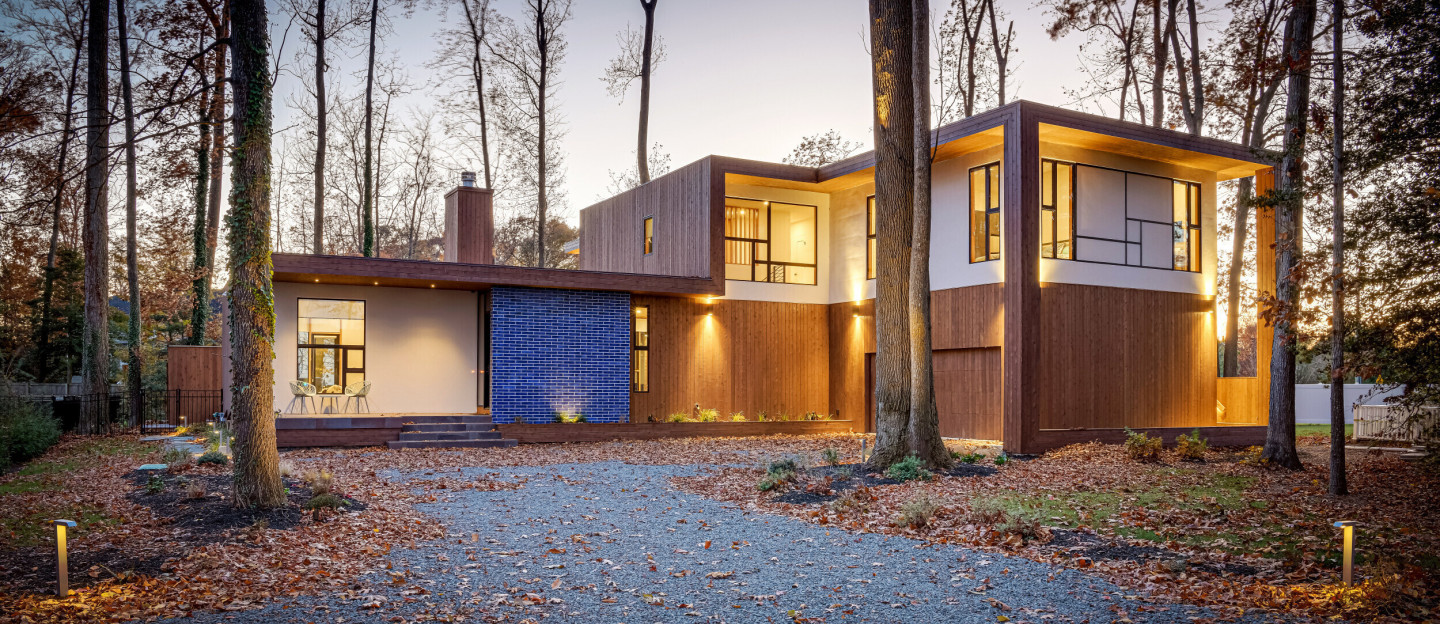 Front view of modern luxury home nestled on a wooded lot, Rehoboth Beach DE