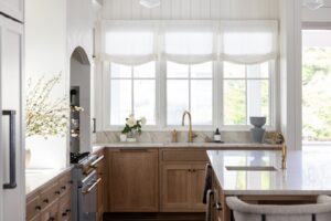 Renovated coastal kitchen with white oak cabinetry and marble counters in a Dewey Beach home by CRx Construction